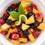 Fruit Salad in a round bowl with pineapple, cherries, blueberries and blackberries