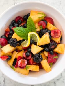 Fruit Salad in a round bowl with pineapple, cherries, blueberries and blackberries