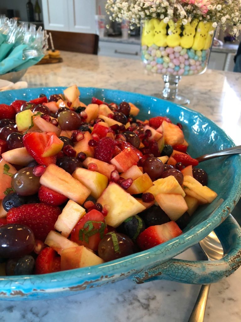 Fruit salad in a big blue bowl with apples and berries