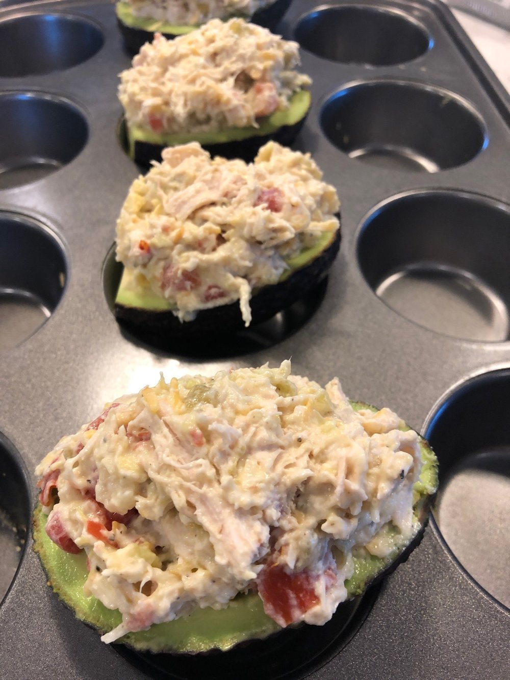 Fill up the avocados with the mixture and place in a muffin tin to keep them up straight.