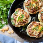 SAUSAGE STUFFED ONIONS in a cast iron skillet