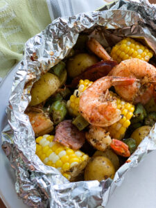 Shrimp, corn on the cob, potatoes and andouille sausage in a foil packet