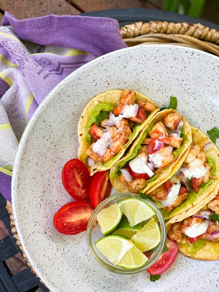 SHRIMP STREET TACOS in a corn shell on a plate with a side of lime