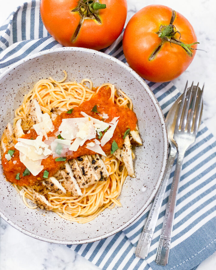 Pomodoro Sauce over grilled chicken that's on top of the angel hair pasta. Parm cheese is sprinkled on top.