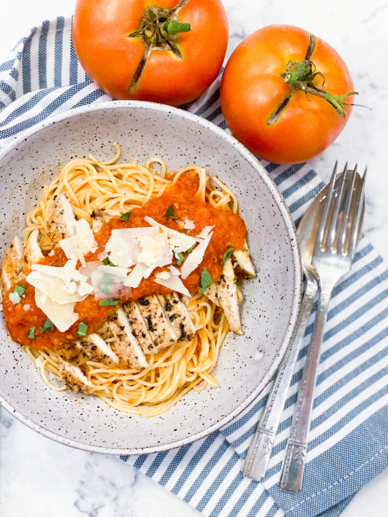 Pomodoro Sauce over grilled chicken that's on top of the angel hair pasta. Parm cheese is sprinkled on top.