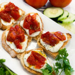 Toasted bread topped with the ricotta cheese spread and roasted tomatoes.