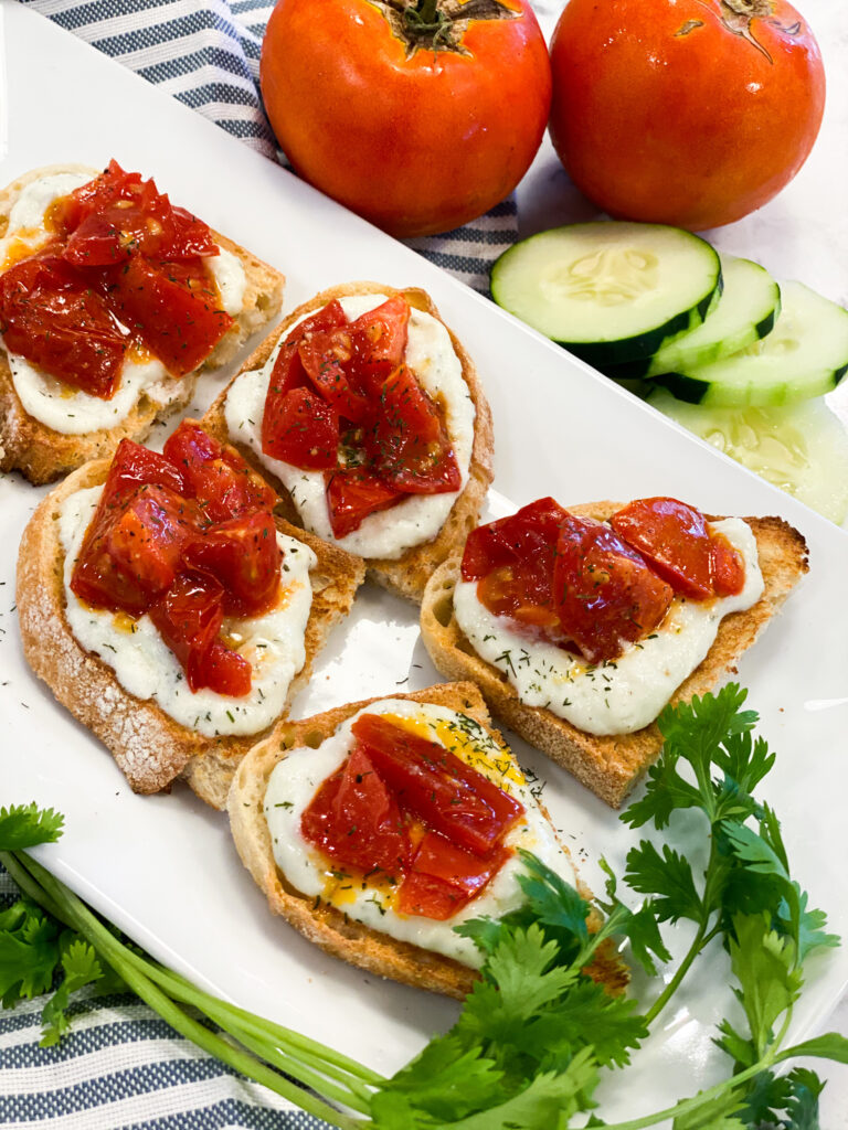 Toasted bread topped with the ricotta cheese spread and roasted tomatoes.