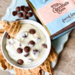 CANNOLI DIP in a white bowl sitting on a light blue tray and waffle cone pieces for dipping