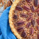 Pecan Pie in a pie plate sitting on a blue towel