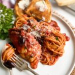 Crock pot Italian chicken and pasta twirled on a fork. Served with crusty bread.