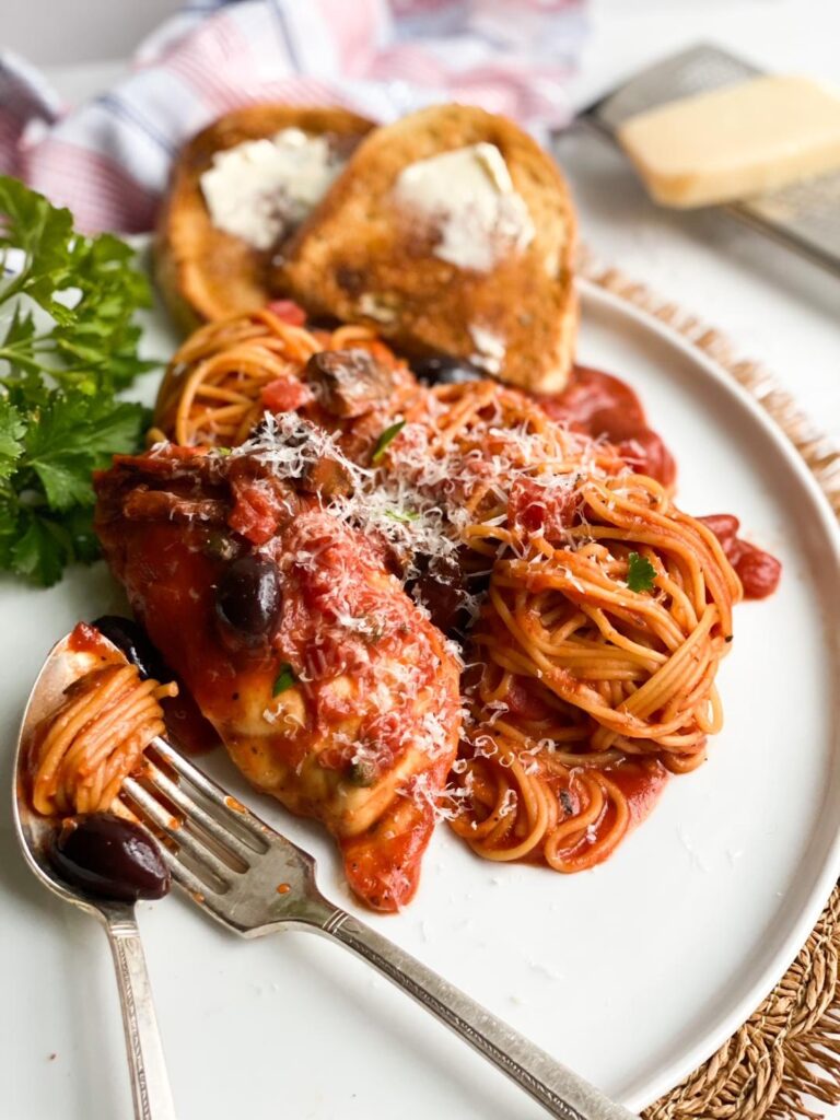 Crock pot Italian chicken and pasta twirled on a fork. Served with crusty bread.